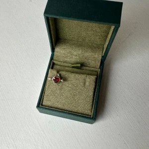 Silverring med röd hjärtformad sten - Säljer en snygg silverörhänge från Maria Nilsdotter med en röd hjärtformad sten som detalj. Örhänget kommer i original ask och har en stilren design som verkligen sticker ut. Perfekt för dig som gillar unika smycken med lite edge. Nypris 1595
