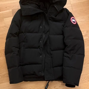Svart pufferjacka från Canada Goose - Säljer en Canada goose McMillan endast använd två säsonger. Väldigt bra skick.