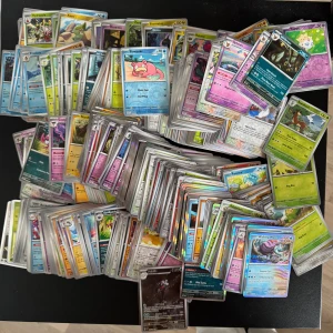 Pokémonkort samling - Stor samling Pokémonkort med färgglada och glittriga motiv av olika Pokémon. Perfekt för dig som vill börja samla, byta eller spela Pokémon TCG. Kort från flera olika serier och generationer.  Holografiska. Ett måste för alla Pokémonfans!