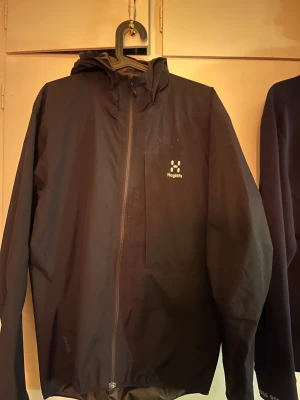 Svart vindjacka från Haglöfs - Svart wind breaker litet hål vid axeln köpt för 1500kr