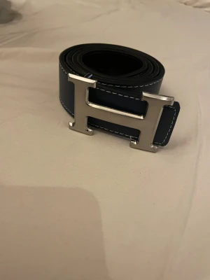 Mörkblått H bälte  - Säljer mörkblått Herrmes bälte i storlek 100 . Det är i mycket bra skick och säljer det pågrund av reselling. Kom privat för fler frågor.