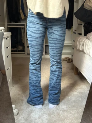 Monki jeans med zebramönster - Säljer ett par blå jeans från Monki med coolt zebramönster i mörkare blå toner. Modellen är bootcut med hög midja och klassiska fem fickor. Materialet är jeans och passformen är normal. Perfekt för dig som vill sticka ut med ett sjukt coolt mönster💙💙