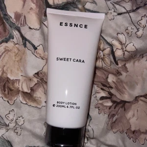 ESSNCE Sweet Cara Body Lotion - Body lotion från ESSNCE i doften Sweet Cara. Kommer i en stilren vit tub med svart lock och rymmer 200 ml. Perfekt för att återfukta huden och ge en fräsch känsla. Oöppnad! 