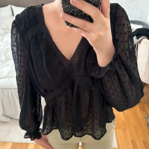 Svart Zara blus - Säljer en svart söt Zara blus. Blusen har volangdetaljer och långa ärmar. Storlek XS men skulle säga att den är som en S🤍