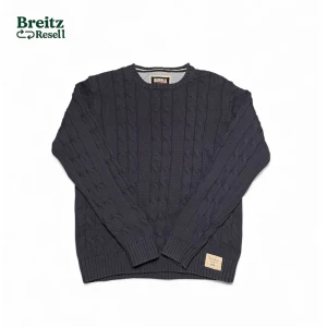 Marinblå cableknit tröja från Bondelid - Snygg marinblå stickad tröja från Bondelid med klassiskt kabelstickat mönster. Tröjan har rund hals, ribbade muddar och en vit Bondelid-patch vid nederkanten. Perfekt för dig som gillar stilren och tidlös design. Inga defekter.                            Storlek L men sitter som M enligt min bedömning