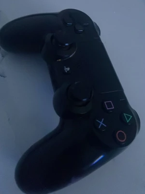 Svart PlayStation 4 DualShock handkontroll - Säljer en svart DualShock 4 handkontroll till PlayStation 4 från Sony. Kontrollern har klassisk design med två analoga spakar, styrkors och de ikoniska PlayStation-knapparna i färg. Tillverkad i plast med en skön form som passar perfekt för gaming.