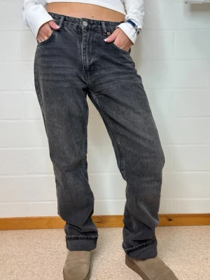 Baggy svarta jeans med rak passform - Säljer ett par svarta baggy jeans med rak passform och klassisk femficksdesign. Jeansen har en tvättad look och hög midja, perfekta för en avslappnad streetstil. Materialet är kraftig denim i bomull.
