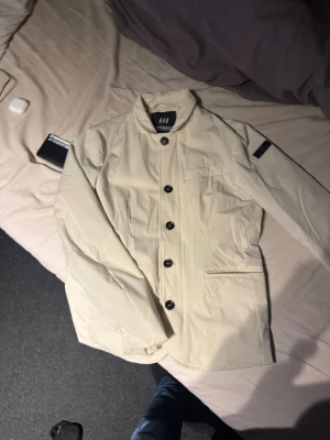 Vit kavaj jacka från hetrego - Stilren vit kavaj jacka från Hetrego med klassisk krage och svarta knappar framtill. Riktig snygg jacka som jag inte kan ha pågrund av längden och hann inte använda den mer än 5 gånger, skick:9,5 storlek: 48(S) Den kostar 3 500kr i nypris. Skriv om minsta funderingar och priset går att diskutera🙌🙌