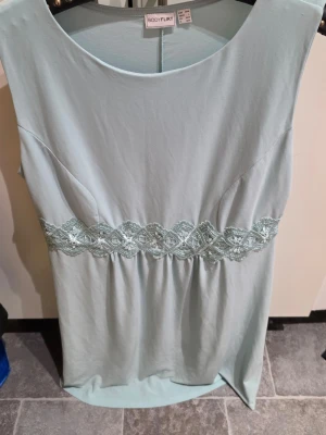 Ljusblå klänning från Bodyflirt L - Snygg ljusblå klänning från Bodyflirt i storlek L. Klänningen har ett brett spetsband i midjan och är ärmlös med rund halsringning. Materialet känns mjukt och lätt, perfekt för varmare dagar.