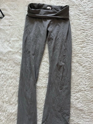 Grå leggings med hög midja från Nelly - Säljer ett par grå utsvängda leggings från Nelly med hög, vikbar midja. De är i mjukt och stretchigt material som sitter skönt på kroppen. Endast testade på, har legat i garderoben sedan dess 🩶