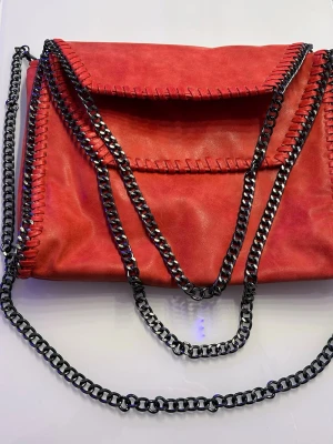 RÖD KEDJEVÄSKA I ÄKTA LÄDER – FALABELLA-MODELL - Säljer en snygg röd väska med kedjedetaljer i mörkt silver. Till skillnad från liknande modeller är denna i äkta läder (rustik kvalitet), vilket ger ett gediget intryck och bra hållbarhet. • Skick: Mycket fint begagnat skick, ren inuti. • Stil: Falabella-lookalike (omärkt). • Material: Äkta läder (köpt utomlands). Perfekt som både handväska och axelremsväska. Skickas spårbart! 📦 #kedjeväska #skinnväska #röd #falabella #äkta läder #trend