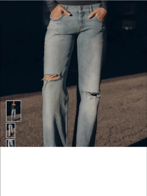 Ljusblå jeans med slitningar - Säljer ett par ljusblå jeans med raka ben och slitningar vid knäna. Jeansen har klassisk femficksdesign och stängs med knapp och dragkedja. Perfekta för en avslappnad och trendig look. Nya med prislpp!