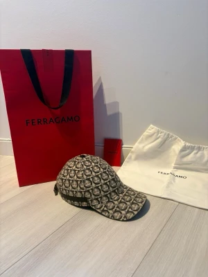 Ferragamo keps  - Snygg keps från Ferragamo, helt oanvänd o äkta såklart, allt på bild ingår, köpt i butiken i puerto banus/marbella. No size är kepsen, vid frågor eller funderingar hör av er, OBS priset är hugget i sten ! 