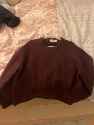 Vinröd stickad tröja Gina Tricot - Mysig vinröd stickad tröja från Gina Tricot i ullblandning. Tröjan har rund halsringning, lång ärm och en lite lösare passform. Perfekt för kalla dagar och enkel att matcha med jeans eller kjol.