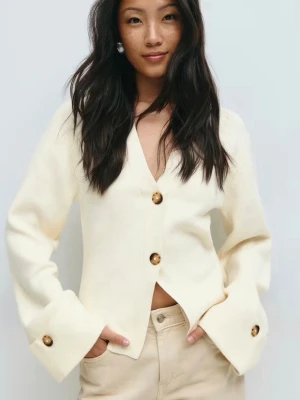 Vit kofta med knappar från Gina Tricot - Stilren krämvit kofta från Gina Tricot med v-ringning och stora bruna knappar framtill och vid ärmsluten. Koftan har en rak, något boxig passform och långa ärmar med breda muddar. Perfekt att styla med jeans eller kjol. Nypris 459 kr! Använd 1 gång och inga defekter eller tecken på användning! Hör gärna av er om ni vill ha fler bilder💗💗