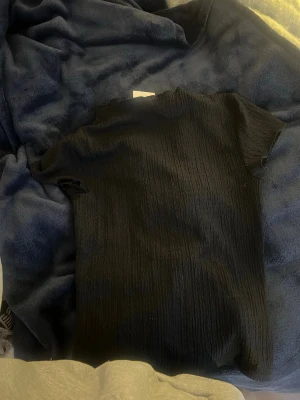 Svart ribbad topp från Kappahl - En svart ribbad topp från Kappahl i storlek XS. 