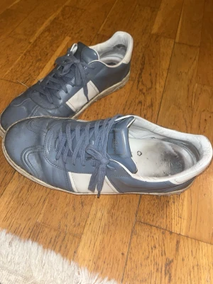 Valentino Flycrew 44 - Snygga sneakers från Valentino i blått och vitt läder. Skorna är i okej skick men kan självklart göra rent dom vid köpfall. 🧼 Skorna är i storlek 44 som motsvarar 10US 👟. På ena skon finns 7 spikar med och  4 saknas, på andra skon finns 6 spikar och det saknas 5🔱 Men det kan man fixa genom att köpa billiga spikar och limma fast dom. Möts i Stockholm men kan även frakta 🚚       Dom kommer även med nya snören som jag har inte använt och två påsar till var sin sko😄