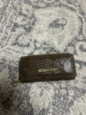 Brun plånbok Michael Kors ormskinn - Snygg brun plånbok från Michael Kors i ormskinnsmönstrat .