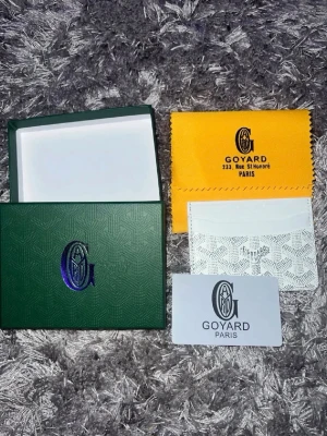 Plånbok  - Snyggt vitt kortfodral från hm med klassiskt mönster och präglad logotyp. Tillverkad i läder och levereras med original ask, gul putsduk och äkthetskort. Perfekt för att hålla ordning på dina kort med stil.