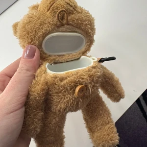 AirPods skal, Nallebjörn  - AirPods skal i nallebjörn format, med en knippa så man kan sätta på sin väska och liknande.