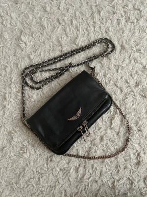 Zadig Voltaire väska - Snygg svart Zadig väska i modellen rock nano. Den har en lite slitage och en del rost men inget man tänker på💕