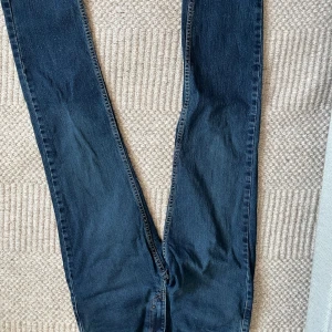 Mörkblå raka jeans - Säljer ett par klassiska mörkblå jeans med rak passform. Jeansen har fem fickor och normal midja. Materialet är denim i bomull och de har en tidlös look som passar till det mesta. Perfekta för dig som gillar enkel och clean stil.