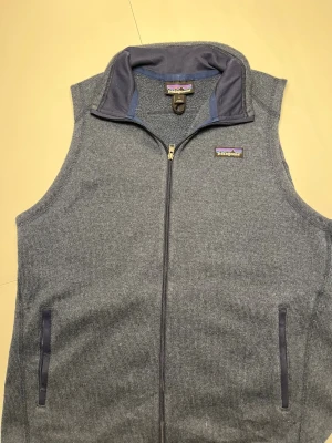 Navy blue fleece väst från patagonia  - En jäkligt snygg patagonia väst i fleece material. Den ända dåliga är att det är ett jätte litet hål på västen men syns verkligen inte när man har på den. Annars är den i ett bra skick. Perfekt i nästan alla väder. Den är i storlek Large men skulle säga att den passar bäst om man är medium för dom är ganska små i storlek:)