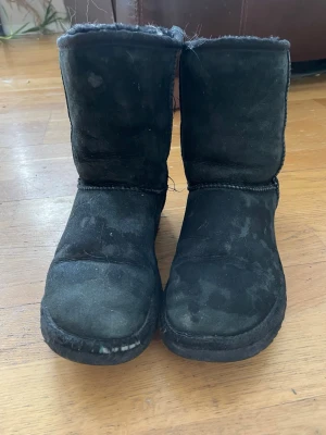 Svarta fårskinnstofflor i boot-modell - Äkta uggs.Matrialet är gjort på mocka och inuti är det ull.dom är lite slinta men dom funkar perfekt att ha under vinter/hösten.