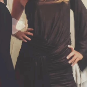 Svart långklänning med omlott - Säljer en svart långklänning med omlottdetalj i midjan och lång ärm. Klänningen har en elegant och figurnära passform.