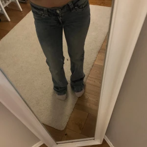 Blå bootcut jeans från Nelly - Snygga blå jeans från Nelly med bootcut-modell och låg midja, och dekorativa sömmar på bakfickorna. Perfekta för dig som gillar en avslappnad men trendig look.