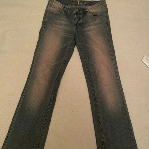 Lågmidjade jeans - Coola jeans med sliten  effekt! Okänt märke, köpta second hand. Riktigt sköna, Lågmidjade. Blå/grå med röda slitningar. Utsvängda men mer åt baggy hållet ❣️ Innerbenslängd: 75cm Midjemått: 35cm