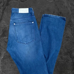 Blå jeans från Acne Jeans  - Snygga blå jeans från Acne Jeans i klassisk rak modell. Jeansen har fem fickor, silverfärgade nitar och normal passform. Tillverkade i 100% bomull för en skön känsla och stilren look. Perfekta för dig som gillar enkel och tidlös denim.