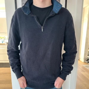 Mörkblå half zip-tröja Massimo Dutti i kashmir - Säljer en mörkblå långärmad tröja från Massimo Dutti med half zip och snygg krage med blå insida. Tröjan är i kashmir bomull och har en klassiskpassform. Nypris 1399kr. Vårat pris 599kr. Grymt skick, inga defekter. Storlek L. Modellen är 180 cm. Skriv vid minsta intresse!
