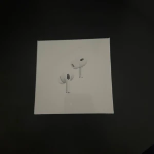 AirPods Pro (2nd generation)  - Säljer ett par AirPods Pro (2nd generation) med MagSafe-laddningsetui (USB-C). Komplett med originalförpackning, extra öronkuddar och laddningskabel. Hörlurarna och etuiet är i mycket gott skick, inga synliga repor eller skador. Perfekt för brusreducering och hög ljudkvalitet.