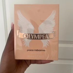 Olympea EdP 80ml ny i kartong - Olympea Eau de Parfum från Paco Rabanne, 80ml. Fräsch och modern doft i snygg förpackning. Innehåller bl.a. alkohol denat, aqua, limonene, linalool, coumarin. Tillverkad i Frankrike. Perfekt för dig som vill sticka ut!
