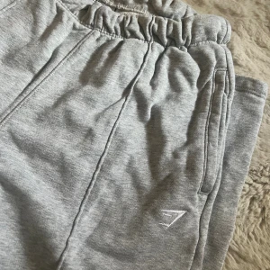 Mjukisbyxor från Gymshark XXS - Snygga ljusgrå mjukisbyxor från Gymshark i storlek XXS. Byxorna har dragsko i midjan och raka ben.