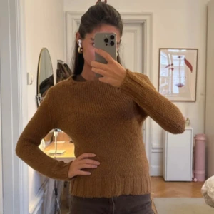Brun stickad tröja från D&G - Säljer en brun stickad tröja från D&G i storlek S. Tröjan har rund halsringning, ribbade muddar och är långärmad. Perfekt för kyligare dagar och har en klassisk, enkel design som är lätt att matcha med olika outfits.
