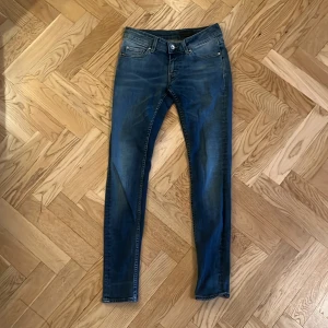 T/J jeans blå 29/30 - Snygga blå jeans från T/J i modellen Slender, tillverkade i Italien. Jeansen har en bra passform med klassisk femficksdesign och läderpatch bak i midjan. Perfekta för dig som gillar en tajt och modern look.