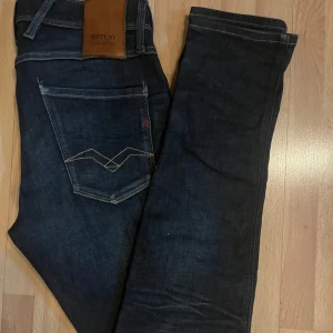 Replay Hyperflex mörkblå jeans - Snygga Replay Hyperflex jeans i mörkblå tvätt med klassiska fem fickor och kontrastsömmar på bakfickorna. Slimmad passform och stretchigt material som ger grym komfort. Perfekt för dig som gillar stilrena och moderna jeans med coola detaljer.