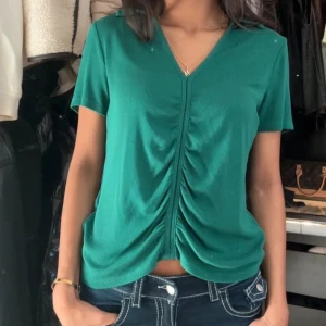 Grön ribbad topp - Jätte snygg grön topp med drapering från Lindex, i storlek M.