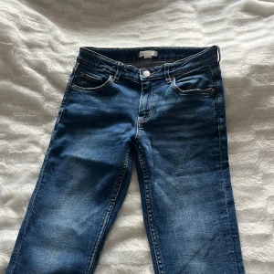 Blå bootcut jeans - Snygga blå jeans från Gina Tricot i klassisk bootcut-modell. Jeansen har fem fickor, låg midja och är tillverkade i mjukt denimtyg. Perfekt för dig som gillar en retro vibe och vill ha ett par jeans med lite utsvängda ben.