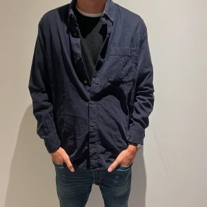 Mörkblå manchester skjorta MNG Man - Snygg mörkblå skjorta från MNG Man i mjuk manchester. Regular fit med klassisk krage, bröstficka och knappar framtill Långärmad modell 