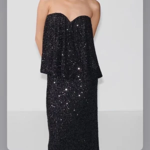 Svart paljett-tubtopp från Gina Tricot - Glittrig svart tubtopp från Gina Tricot, storlek small. Helt oanvänd.