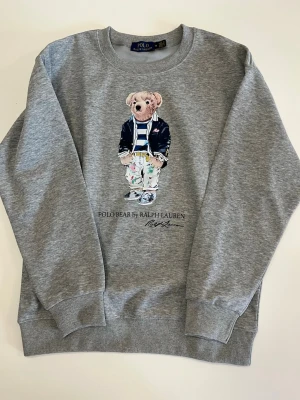 Grå Ralph lauren tröja - Ralphlauren Björn tröja. I storlek M men passar också även mindre. Knappast använd. Skick: 9/10