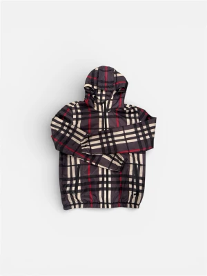 Rutig vindjacka med huva från burberry - Säljer en snygg vindjacka med klassiskt rutigt mönster i svart, beige och röda detaljer. Jackan har huva, dragkedja framtill och två fickor med dragkedja. Tillverkad i lätt polyester som passar perfekt när det blåser ute.