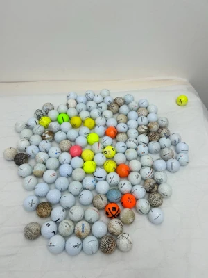 Ingen väst på bilden - Bilden visar inga västar utan endast ett stort antal golfbollar i olika färger och skick.