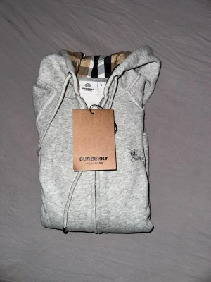 Burberry hoodie med dragkedja - Grå burberry hoodie med dragkedja. Storleken är som en S. 