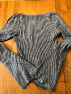 Grå ribbad långärmad topp - Säljer en grå ribbad topp med lång ärm och rundad halsringning. Öppen rygg en del väldigt fint skick skicka pm vid intressen storlek xs