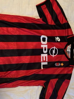  AC Milan fotbollströja - Äkta Inter Milan fotbollströja. I storlek L, i färgen svart och röd. Tröjan är i toppen skick. Den perfekta T-shirten inför sommaren!
