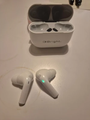 OBright True Wireless Earbuds - Säljer två par OBright trådlösa hörlurar med laddningsetui, en vit och en svart. Båda paren är i gott skick med synliga LED-indikatorer och laddningsetui. Perfekt för musik, samtal och träning. Mindre spår av användning kan förekomma.